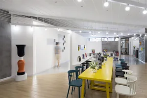 A modern office space with yellow tables and blue chairs.