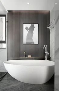 Modern bathroom design featuring a freestanding white marble bathtub, black and white photograph, and dark wooden paneling.