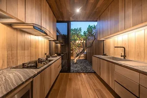 Modern minimalist kitchen with wooden cabinets and marble countertops