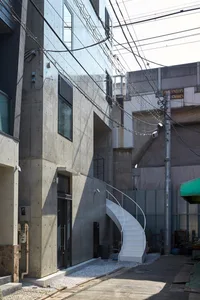 Concrete building exterior featuring a modern staircase in a city environment.