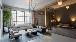 Modern industrial living room featuring concrete, metal, and wooden walls and furniture