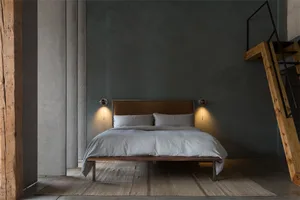 Minimalist bedroom with a bed, pillows, and a wooden headboard.