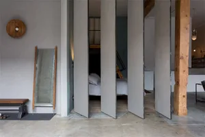 A minimalist concrete architectural design with open spaces and industrial-style furnishings.