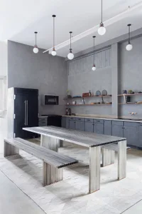 A modern industrial kitchen with metal and concrete elements.