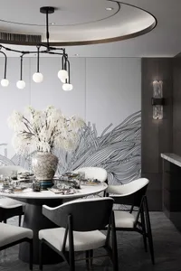 A modern dining room with white and black marble table, chairs with cushions, and a vase of white flowers.
