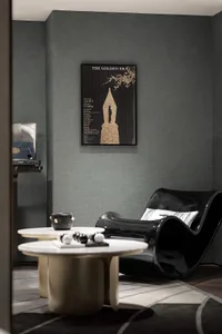 A modern living room featuring metal, leather, and fabric furnishings and a black curved chair.