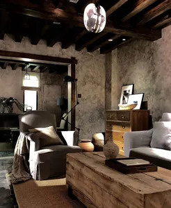 A cozy industrial-style living room featuring rustic wooden furniture and semi-transparent ceiling beams.