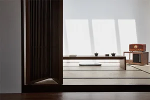 A minimalist Japanese-style room with tatami mats, wooden furniture, a low table, and tea set.