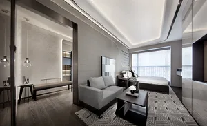 A modern living room with minimalist decor, featuring a gray fabric sofa, a low coffee table with decorative items, and moder