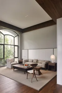 Modern minimalist living room featuring a sofa, armchair, coffee table, and floor lamp.