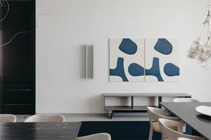 Modern living room with polished concrete floor, white walls, and abstract blue art on the wall.
