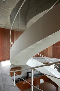 Modern spiral staircase made of white metal and wooden elements.