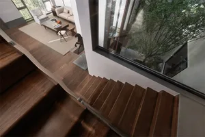 Modern, wooden staircase with glass railings in a contemporary interior design setting.