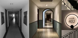 Modern corridor with concrete walls, tiled flooring, and metallic handrails