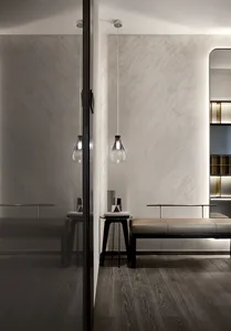 Modern home entry with concrete walls, a metal and leather bench, and minimalist lighting fixture.