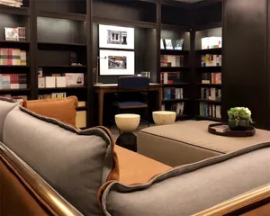 A cozy, modern home library with comfortable seating, bookshelves filled with books, and a warm, inviting atmosphere.