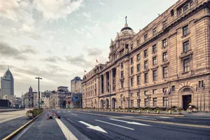 A wide-angle photograph of an urban street featuring a historic brick building.