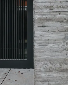 Modern minimalist building exterior featuring textured concrete panels