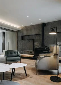 Modern living room with wooden flooring, leather furniture, and marble table top.