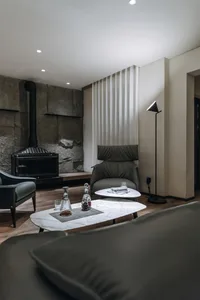 Modern minimalist living room featuring marble coffee tables and a leather armchair, providing a comfortable and sophisticate