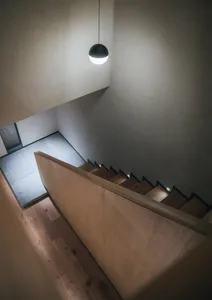 Modern minimalist staircase with wooden steps and railings.