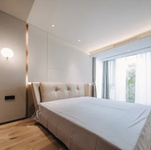 Modern bedroom with a white bed frame and white curtains.