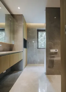 Modern minimalist bathroom featuring marble tiles and fixtures.