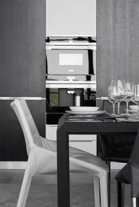 Modern kitchen with white leather chairs and black dining table.