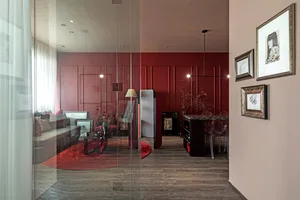 A modern living space with a red accent wall and wooden furnishings.