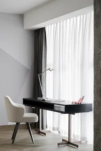 A modern workspace with a white curtain and a black desk in a minimalist interior design setting.