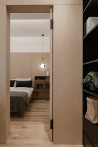 Minimalist bedroom with wooden furniture and white walls.