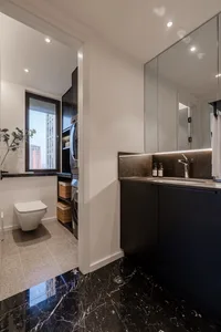 A modern bathroom and laundry room with marble flooring and minimalist design.