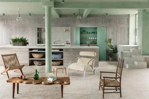Modern industrial living room with wooden furniture, concrete floor, and green accents
