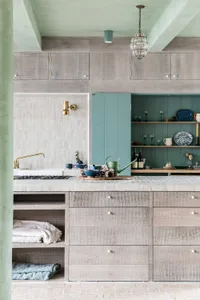 A modern kitchen featuring wooden cabinets, white countertops, and glass backsplash.