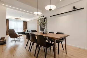 Modern living room with wooden furniture, featuring black chairs and a wooden table.