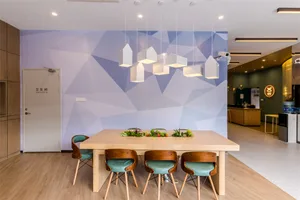 A modern meeting room featuring wooden tables and chairs with metal accents.