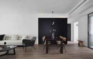Modern minimalist living and dining room featuring black accent wall.