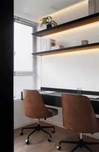 A modern office space featuring wooden accents, minimalist design, and a sleek desk setup with shelves and books.