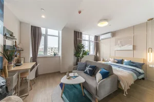 A modern residential bedroom featuring fabric upholstery, wood flooring, and a variety of decorative elements.