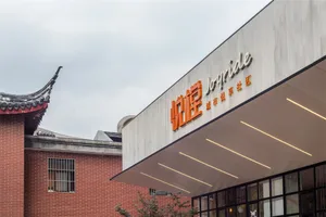 Modern restaurant exterior made of concrete with large windows and a sign reading "Joyride"