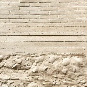 A beige exterior wall with brick and concrete textures