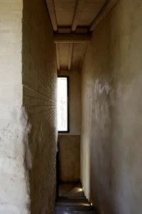 A narrow staircase with brick walls and concrete steps