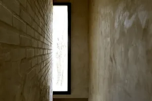 Minimalist corridor with concrete and brick walls and a bright window