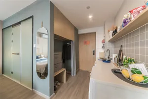 A modern apartment's interior showcasing a kitchen area with an open space for storage and organization, featuring mixed mate