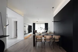 A modern black and white living space with minimalist decor and a black accent wall.