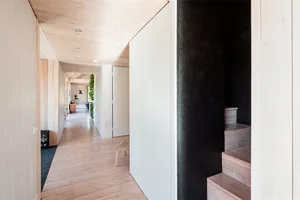 A modern minimalist house interior with wood flooring and white walls.