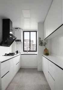 A contemporary kitchen with sleek white marble countertops and cabinets, featuring a sink, stove, and minimalist design eleme