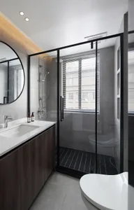 Modern bathroom featuring a glass-walled shower enclosure with dark wood cabinets and white porcelain floor tiles.