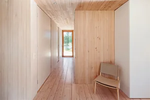 A modern interior design featuring wooden flooring and walls.