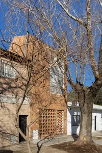 Modern house with brick and concrete exterior, featuring a geometric door and window designs.